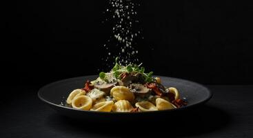 Orecchiette pasta with mushroom sauce and cheese being sprinkled on top photo