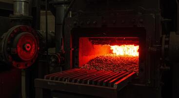 Industrial furnace burning biomass pellets on a glowing combustion grate photo