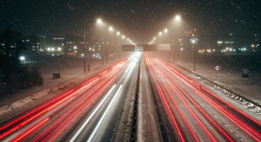 Long exposure of vehicle light trails on a snowy highway at night photo