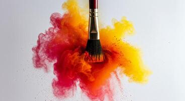 Paintbrush swirling through vibrant red and yellow powder explosion creating abstract color cloud photo