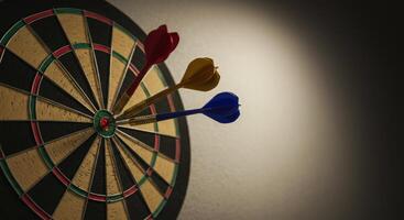 Three darts hit the bullseye of a dartboard representing target and achievement photo
