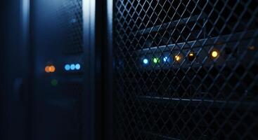 Close up of server rack mesh door with status lights glowing in a dark data center photo