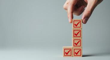 Hand placing checkmark block on stack representing completion and success photo