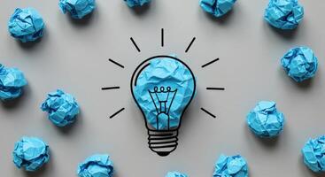Creative Idea Concept with Crumpled Blue Paper Lightbulb and Scattered Balls photo