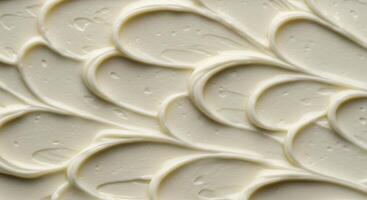 White cream texture with decorative wavy swirl pattern close up photo