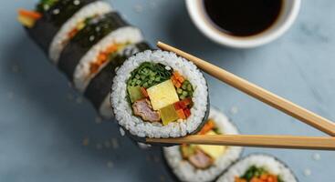 Delicious sliced Kimbap rolls with chopsticks and soy sauce Traditional Korean food photo