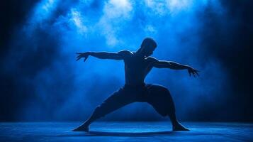 Silhouetted Male Dancer Posing in Blue Smoke photo