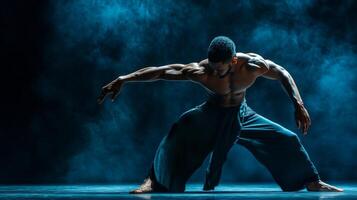 Muscular Male Dancer in Blue Smoke Performing a Dance Move photo