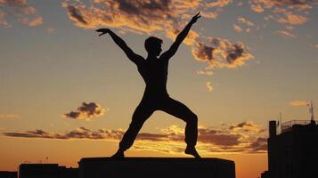 Silhouette of a Man Performing a Dance Pose at Sunset photo