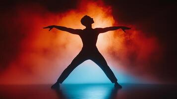 Silhouette of a Dancer Posing in Red and Blue Smoke photo