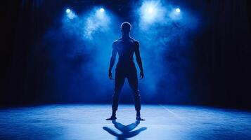 A Male Dancer Silhouetted in Blue Stage Lighting photo