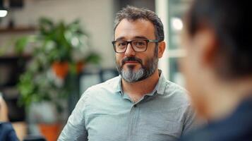 A man with a beard and glasses looking thoughtfully photo