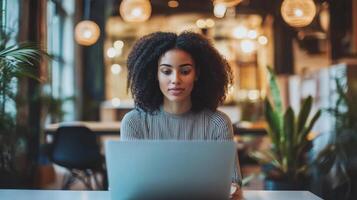 Woman with curly hair working on a laptop in a cafe photo