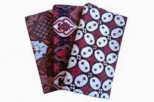 Three red and black napkins with designs on them photo