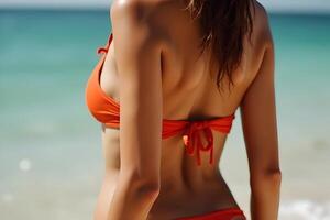 Woman in Orange Bikini Enjoys Summer Day at the Beach by Ocean photo