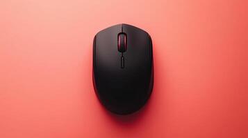 A black computer mouse on a pink surface photo