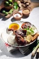 Fried duck known as nasi bebek served with rice, vegetables and sambal Indonesian food style. served with chili sauce and cucumber. Indonesian food photo