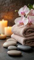 Relaxing spa setting with candles, towels, and orchids for a calming ambiance photo