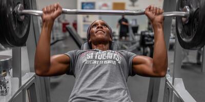 Focused individual performs chest press at gym showcasing determination and strength photo