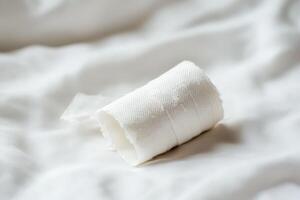 Bandage roll resting on a soft surface photo