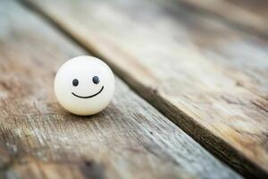 Smiling ball on a wooden table during daytime photo