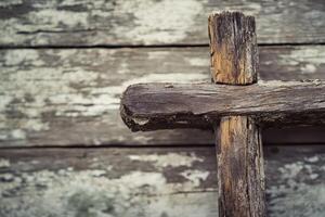 Rustic wooden cross against weathered background photo
