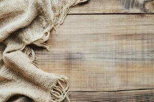 Natural burlap fabric draped on wooden surface photo