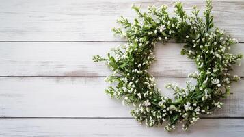 Fresh flower wreath on rustic wooden background photo