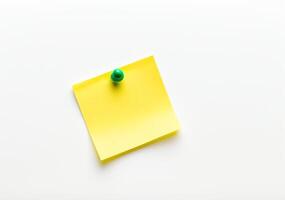 Yellow sticky note with green push pin isolated on white background in high definition photo