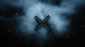 Dark, aerial view of a large X shape amidst city, shrouded in mist photo