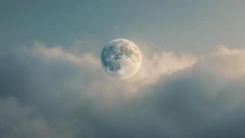A full moon is seen in the sky above clouds photo