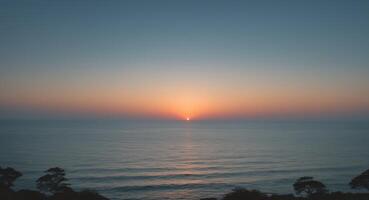 Ocean Serenity. A Peaceful Sunset Over Calm Waters, Framed by Silhouetted Trees photo