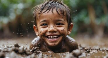 A young boy is smiling while playing in the mud photo