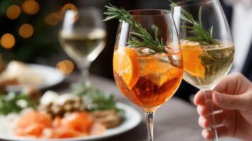 A person holding a glass of wine with a garnish photo
