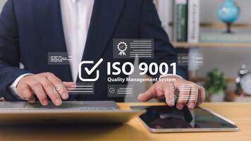 ISO 9001 Standard certification standardisation quality control concept, Certified and quality, Businessman use computer and tablet with text ISO 9001 for quality management of organizations. photo