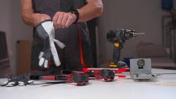 Man putting on safety gloves in workshop video