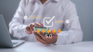 Customer satisfaction survey via online application, Customers use smartphones to express their feedback with emoticons ranging from happy to sad, Providing the best service and product quality 5 star photo