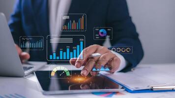 Businessman using laptop and tablet to analyze business data, Database and indicators, Business data dashboard, Company growth goals, Development, marketing and sales, Data management system with KPI. photo