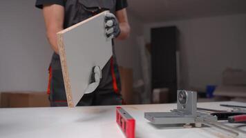 Carpenter holding furniture panel in workshop, preparing part for cabinet assembly video