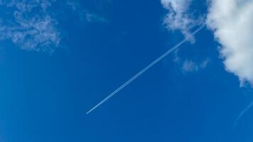 A sleek jet stream carves through azure skies, epitomizing the wanderlust of International Aviation Day and Sky Awareness Week photo