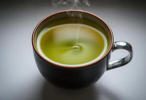 cup of green tea with steam rising from it photo