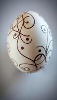 white and brown decorated egg on a table photo