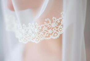 close up of a white veil with a lace on it photo