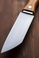 knife with a wooden handle on a wooden table photo