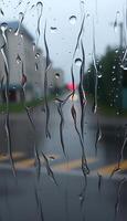 rain covered window with a red car in the background photo