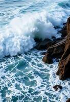 large wave crashes into the rocks at the beach photo
