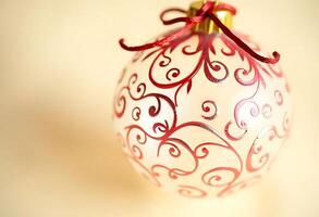 red and white ornament with a red ribbon photo