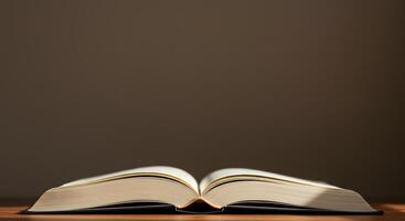 An open book on a table with a light shining on it photo