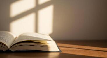 An open book on a table with sunlight streaming in through the window photo