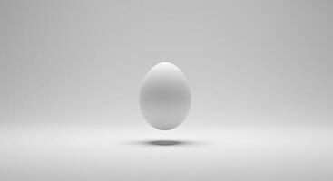 A white egg floating in the air on a gray background photo